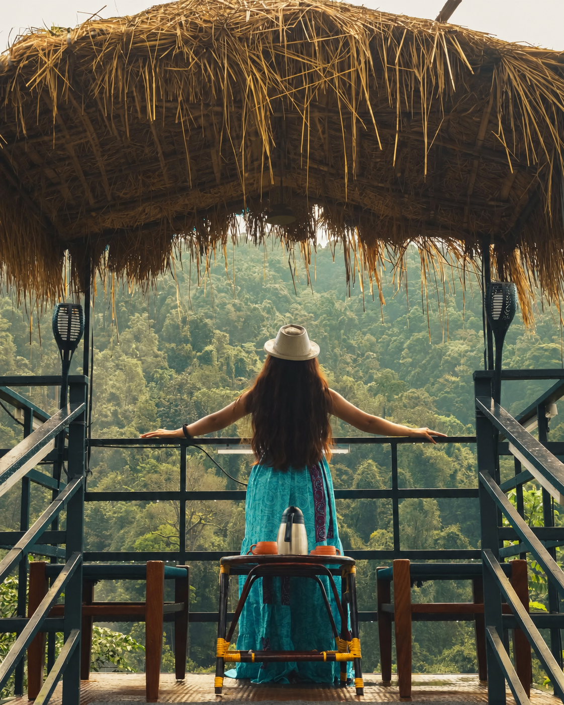 Guest overlooking lush jungle valley from thatched pavilion at Holistic Stay Eco Resort