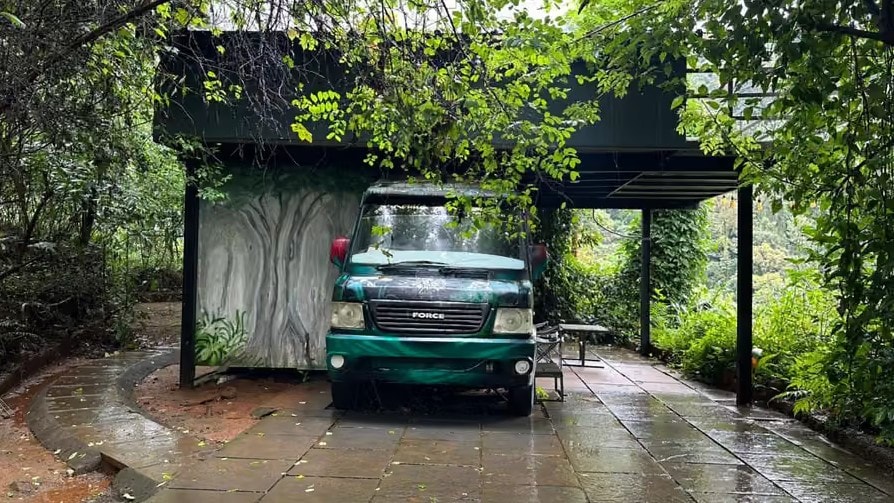 Green caravan van parked under a jungle pergola at Holistic Eco-Resort